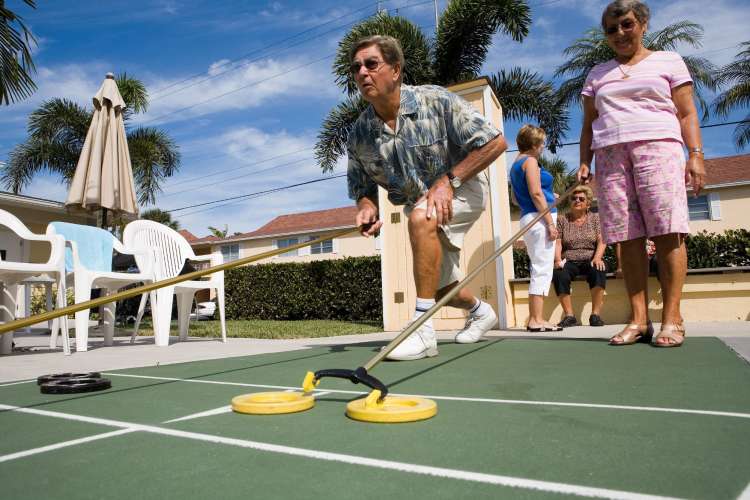 A man playing shuffleboard outside