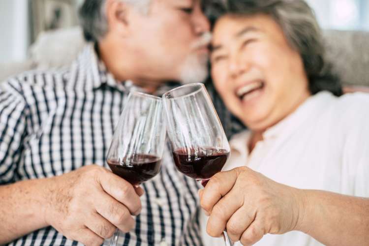 a senior couple toasting with wine glasses