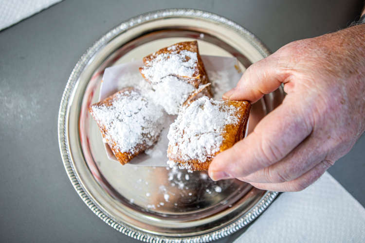 man enjoying beignets on a food tour