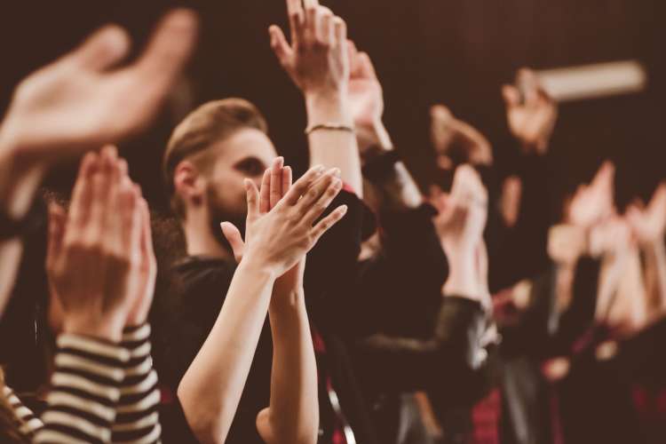 a crowd cheering and clapping at a show