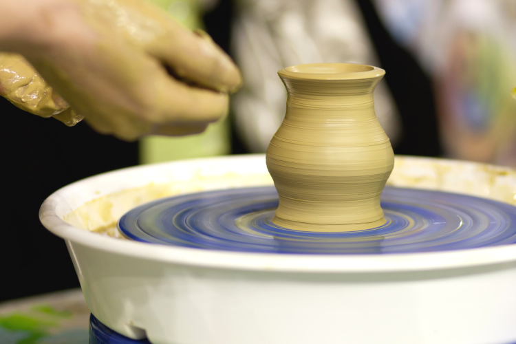 a spinning pottery wheel and a small pot taking shape