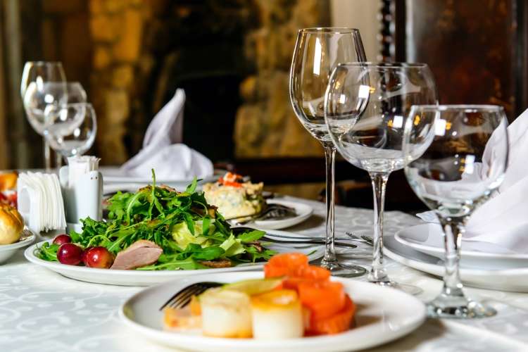 restaurant table with gourmet plates of food and wine glasses