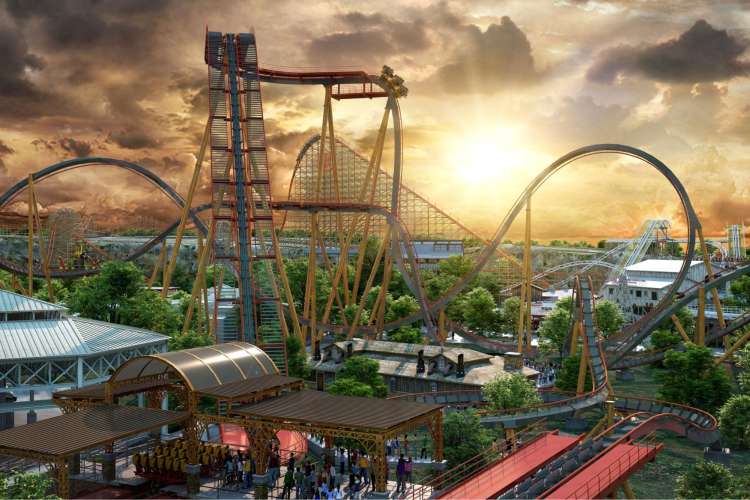 a view of roller coasters and park rides against a warm sky