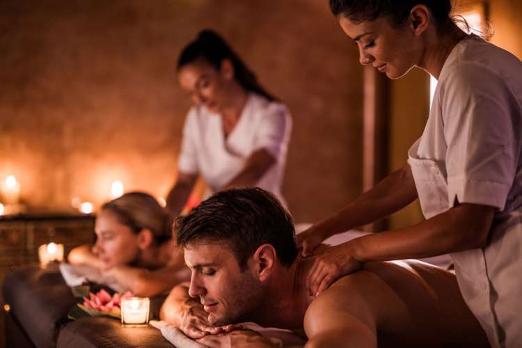 a couple on massage tables having shoulders rubbed