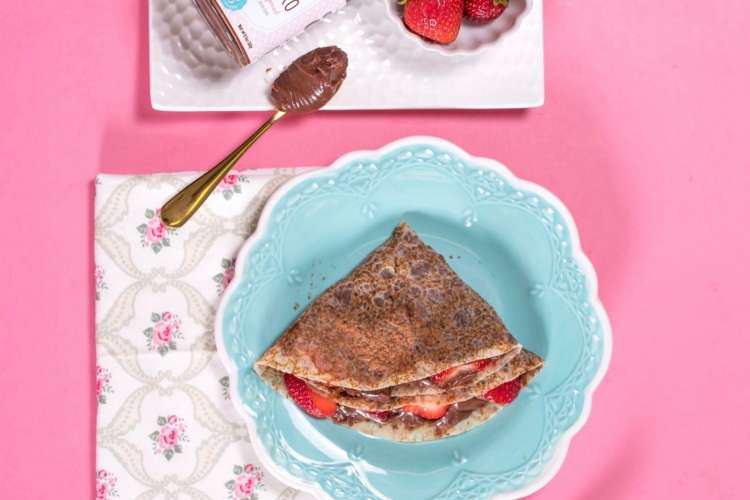 a chocolate crepe with fresh fruit on a colorful table setting