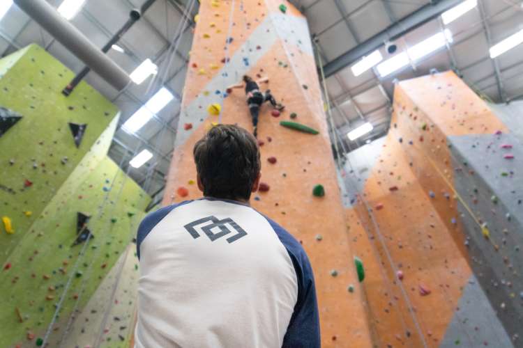 spotter watching a climber at a nashville rock climbing gym