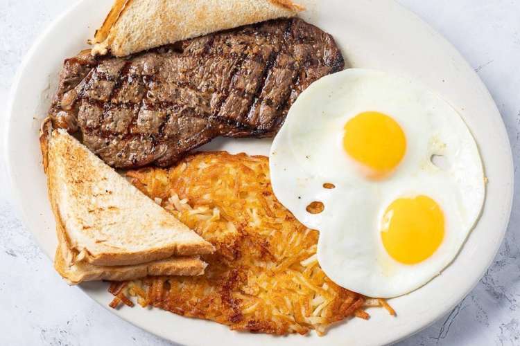 a plate of steak and eggs with sliced toast