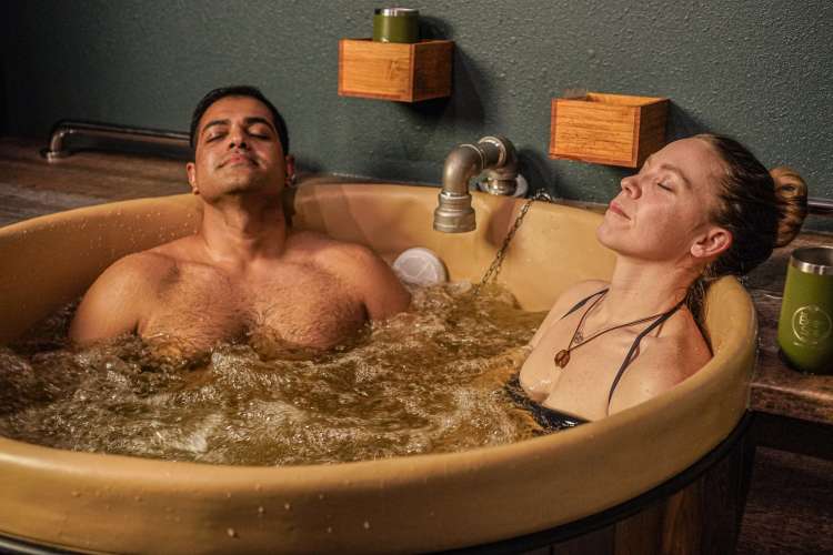 couple soaking in a round tub at the beer spa