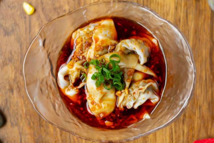 wontons in a spicy-looking red sauce