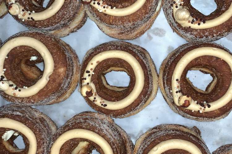 a row of frosted chocolate doughnuts