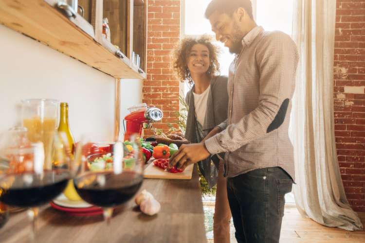 a couple cooking together in a kitchen