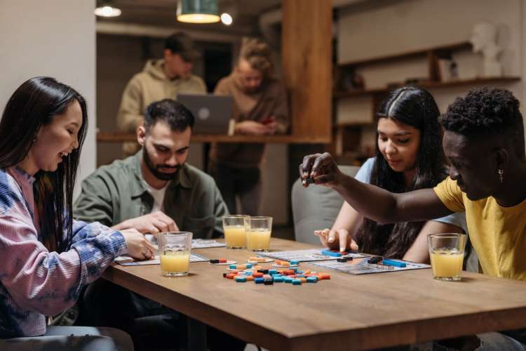 four people at a table playing a board game together