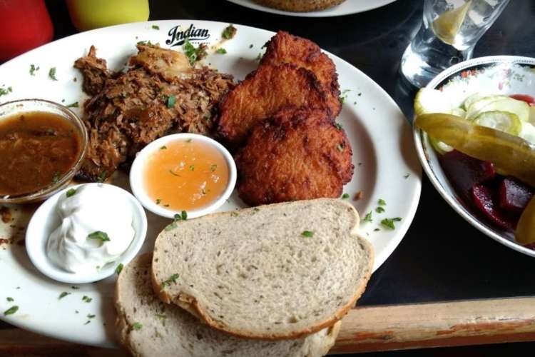 a plate of brisket and bread with sauces