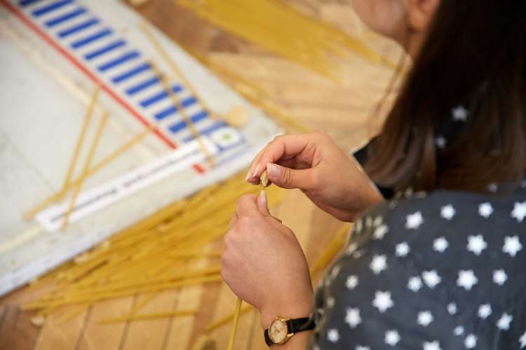 an employee building a marshmallow spaghetti tower