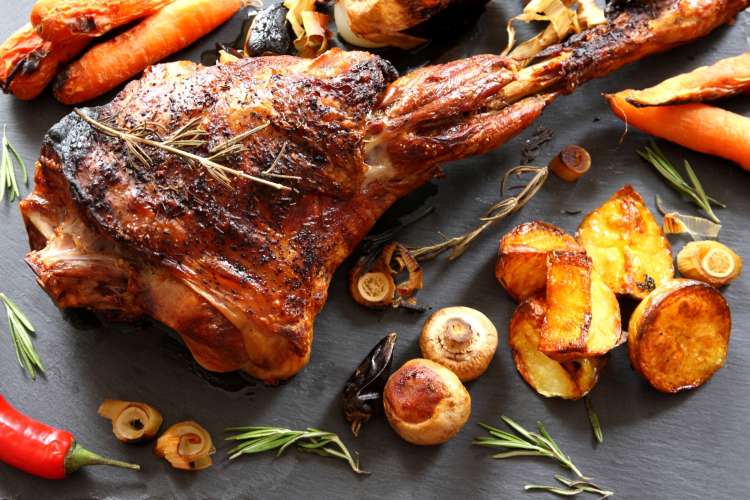 roasted leg of lamb with potatoes, mushrooms, carrots and rosemary