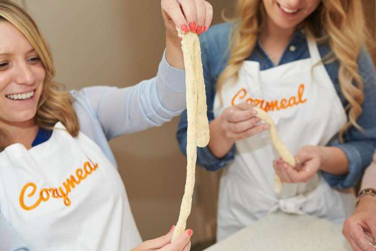 woman stretching homemade dough during a cooking class