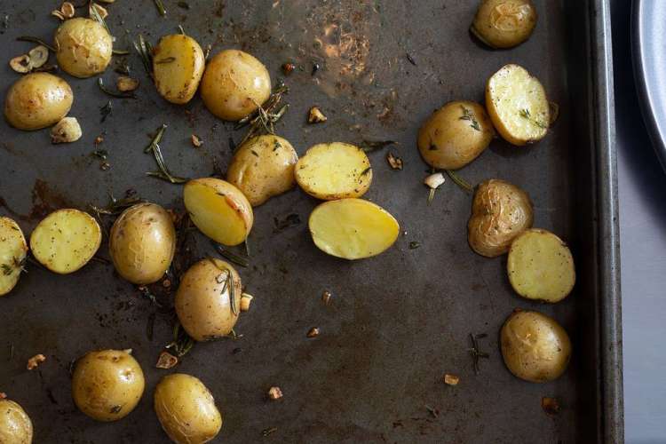 New potatoes on a baking sheet with rosemary