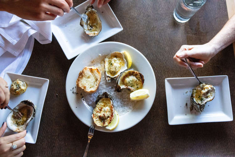 people enjoying oyster rockefeller on a food tour