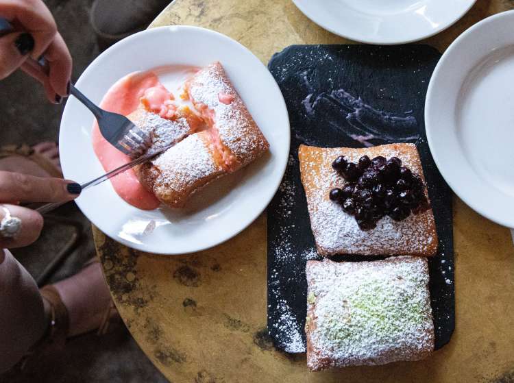 Food tour participants enjoying beignets with fruit