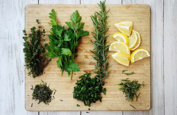 parsley, thyme, rosemary and lemon on a cutting board