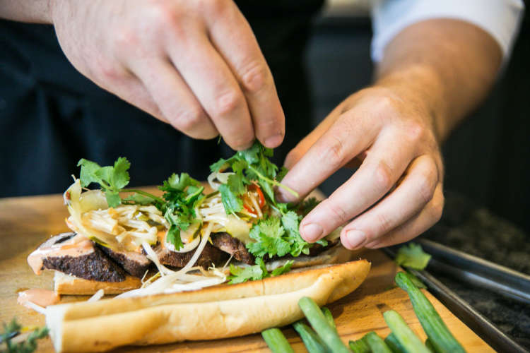 chef plating a bahn mi