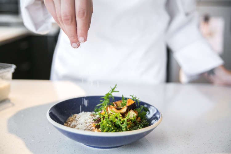 private chef plating a gourmet salad