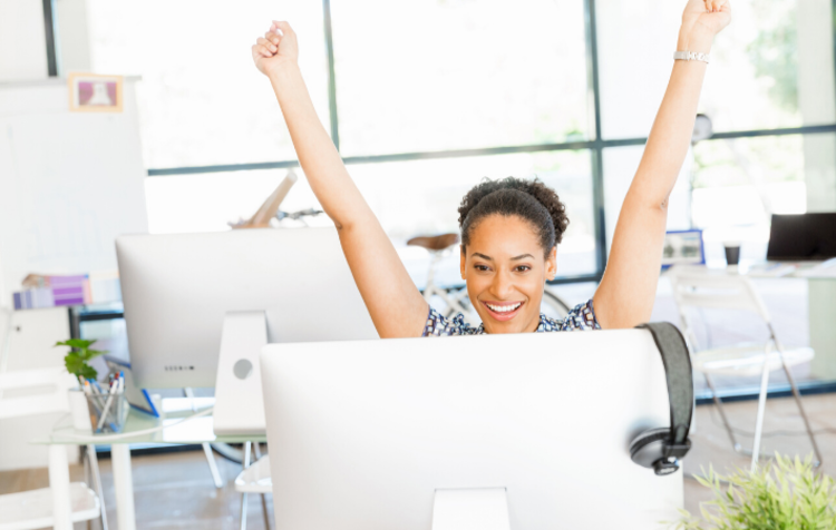 A woman raising her hands in front of a screen during a virtual ice breaker game