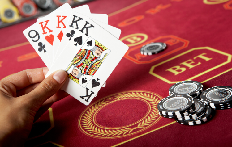 A hand holding five cards next to casino chips, which is ideal décor for a 50th birthday party idea