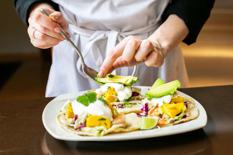 private chef plating avocado onto tostadas