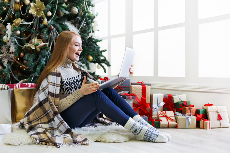 young woman playing virtual never have i ever by a christmas tree