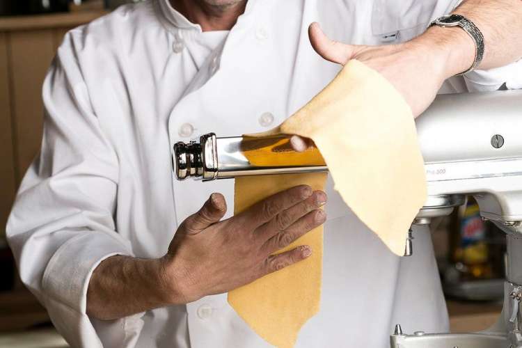 chef rolling pasta dough in a cooking class