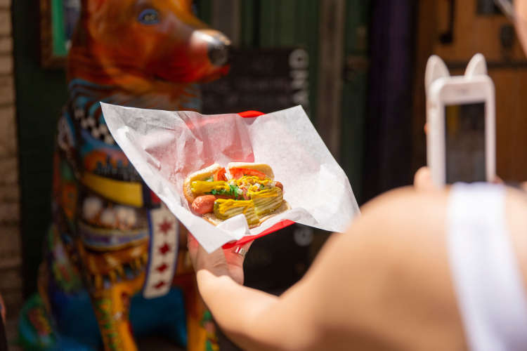 enjoying a hot dog on a food tour