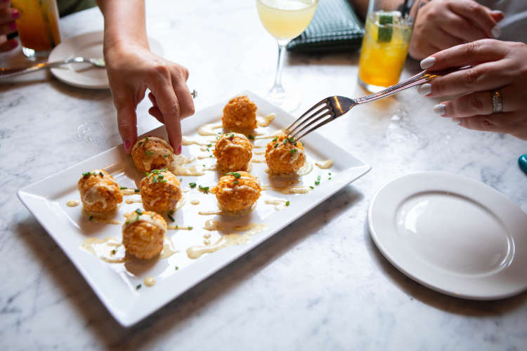 people enjoying fried appetizers on a food tour