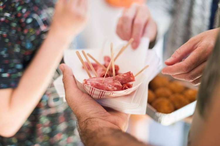 a group of people sharing deli meats together on a food tour