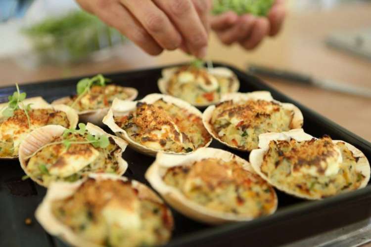 a chef garnishing a shellfish dish