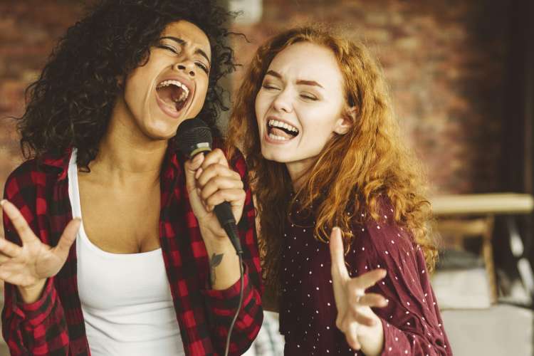 two women singing karaoke together