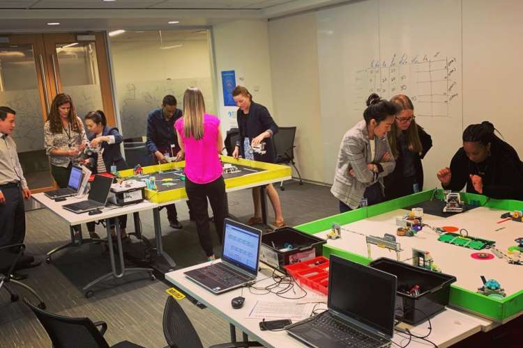 a group of co-workers work on a robotics team building event