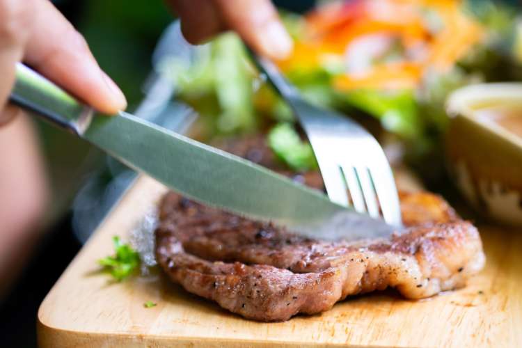 a diner cutting into a Kobe wagyu steak