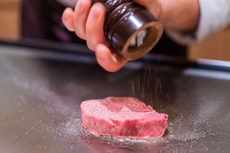 a steak being salted