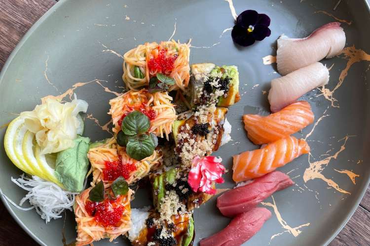 a sushi roll alongside nigiri sushi