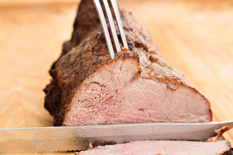 slicing into a tri-tip steak