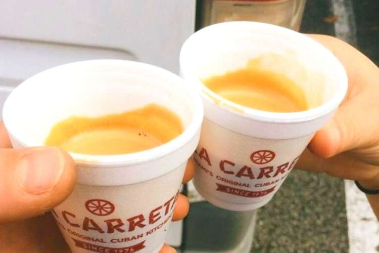 two people drinking cafecito from a Cuban restaurant