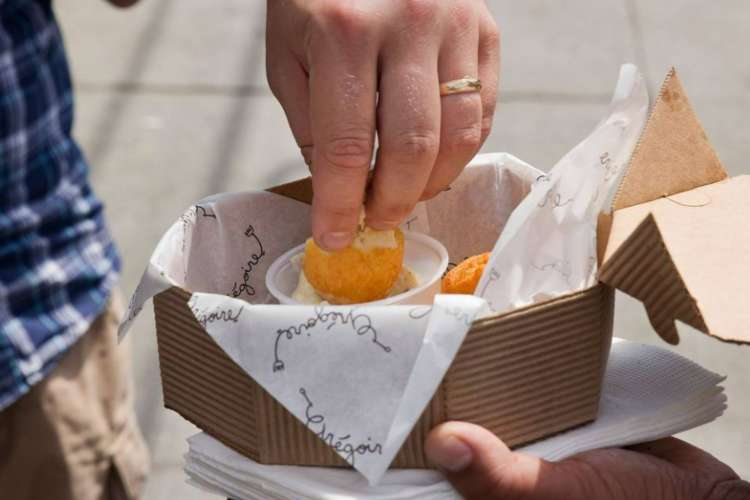 a man dips an appetizer in sauce on a food tour