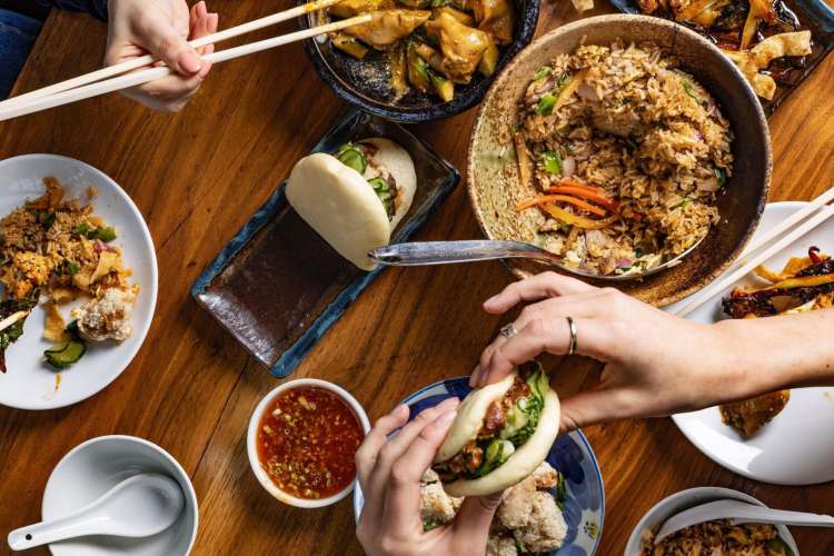 a variety of Chinese cuisines being eaten at a table