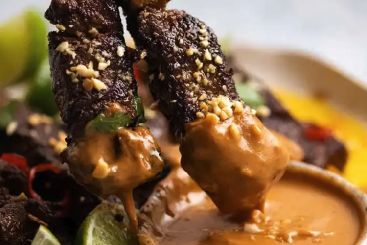 beef satay with thai peanut sauce is paired with a tangy peanut sauce and a spritz of lime