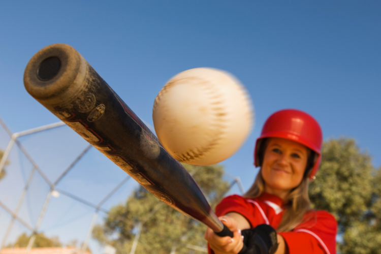Woman playing softball outside during a team building in Los Angeles