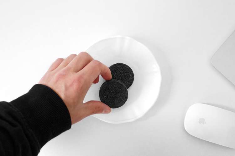 hand grabbing oreos on plate