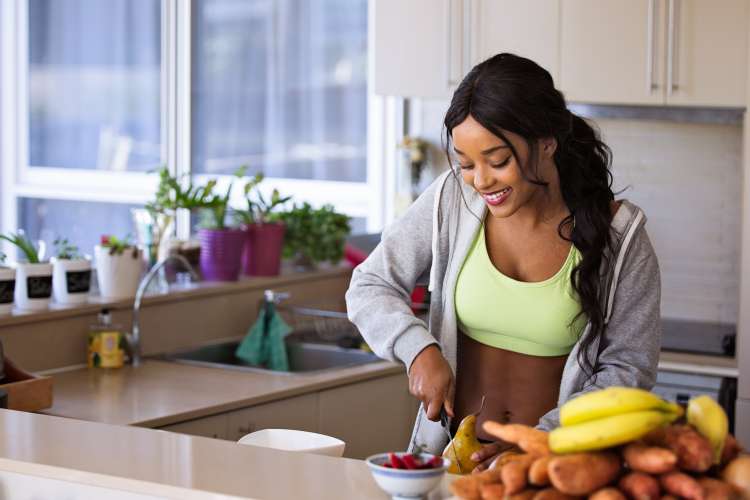 young woman slicing fruit in a kitchen