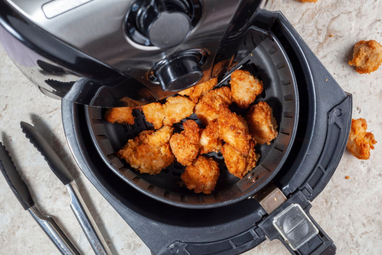 air fryer basket with crispy chicken nuggets