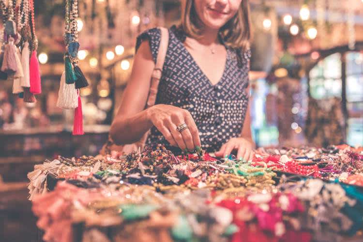 woman looking through jewelry at a store